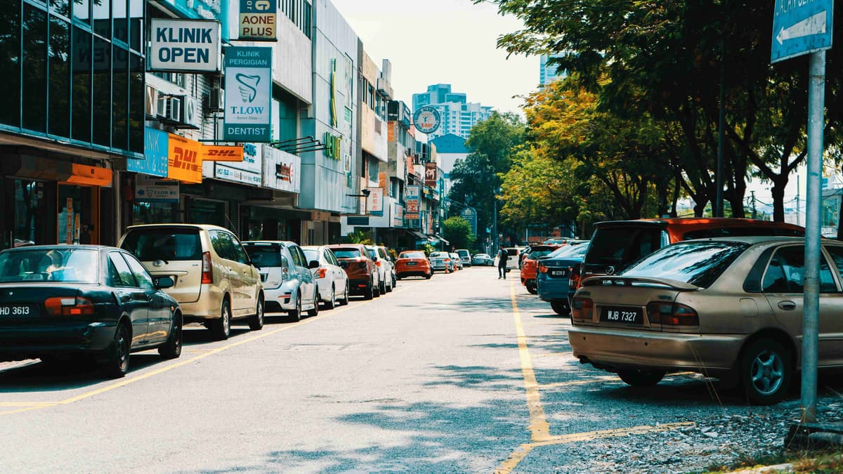 شارع مزدحم بالسيارات المتوقفة والمحلات التجارية ماليزيا