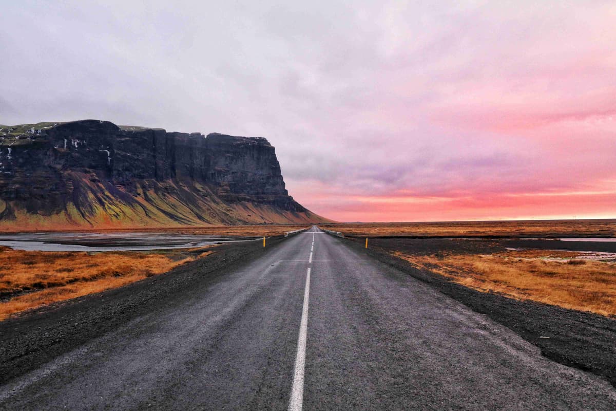 Open Road Toward Majestic Cliffs at Sunset