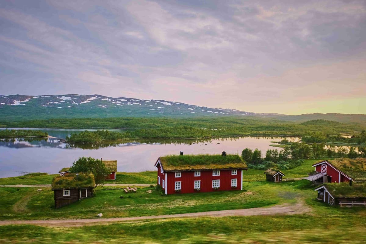 شفق الصيف الاسكندنافي مع المنازل الحمراء التقليدية