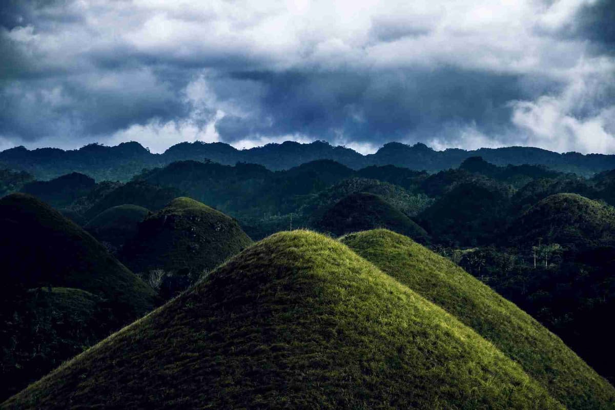 Verdant Chocolate Hills rising among misty peaks in Bohol, Philippines.