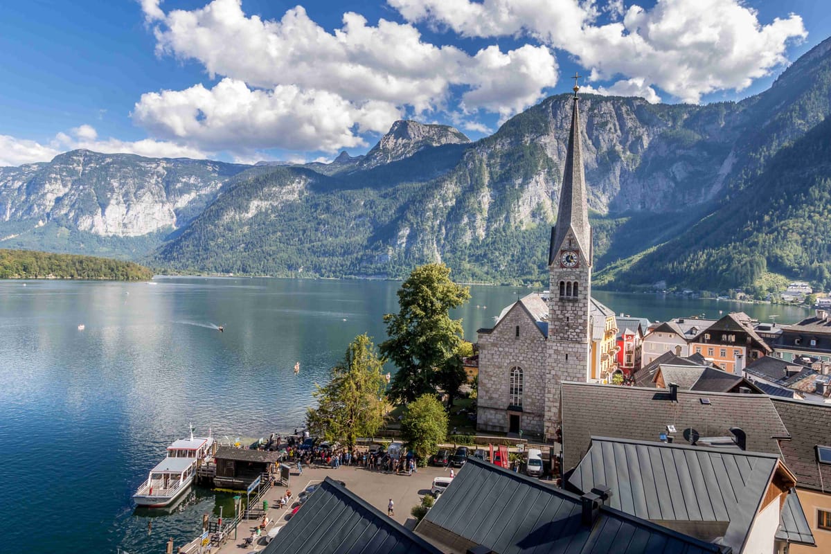 Hallstatt village with church, lake, and Alps in Austria.
