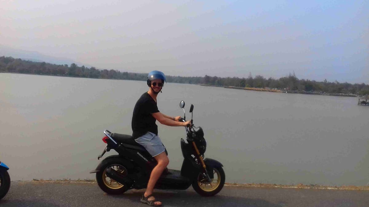 Mark on a scooter overlooking a body of water.