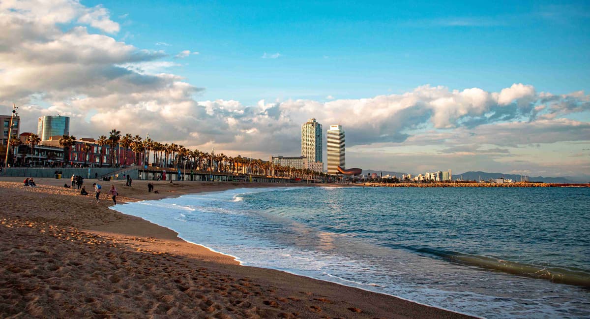 Barceloneta Beach with City Skyline and Cloudy Sky