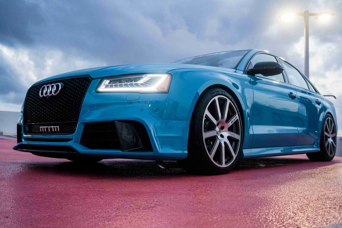 Blue Audi RS5 Coupe On Wet Pavement Under Streetlights