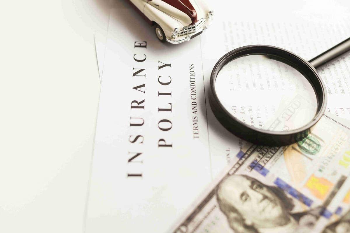 Car Insurance Policy Document with Magnifying Glass and Money