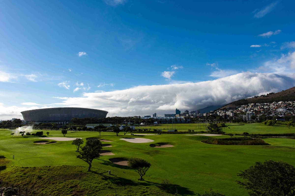 Munte acoperit cu nori, cu vedere la terenul de golf și la stadion