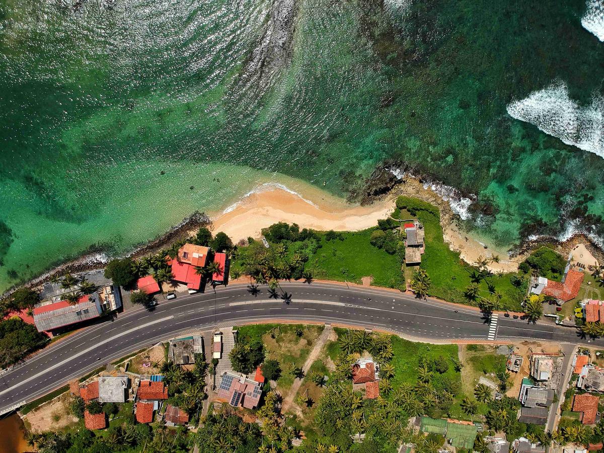 Coastal_Road_by_Turquoise_Waters_Aerial_View