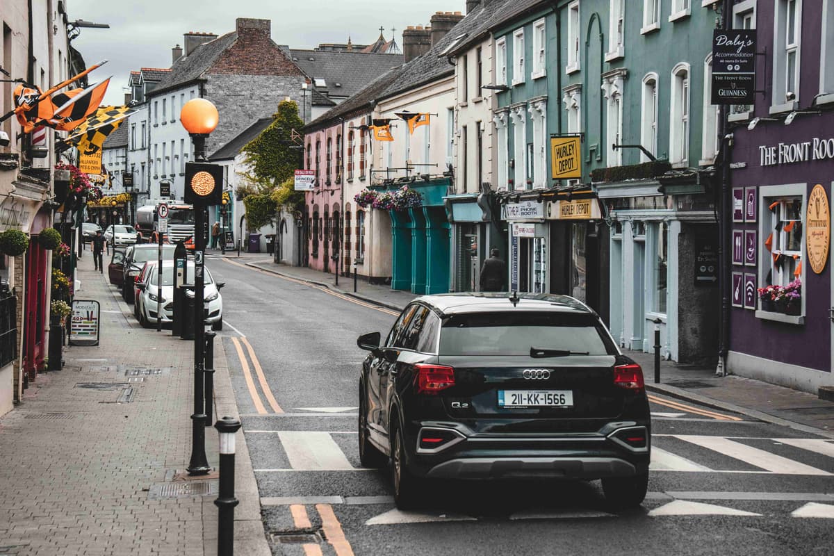 Colorful Town Street with Flags and Parked Cars