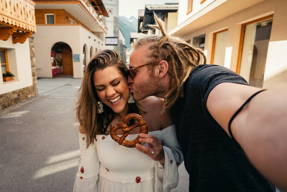 Couple Taking Selfie with Pretzel in European Town