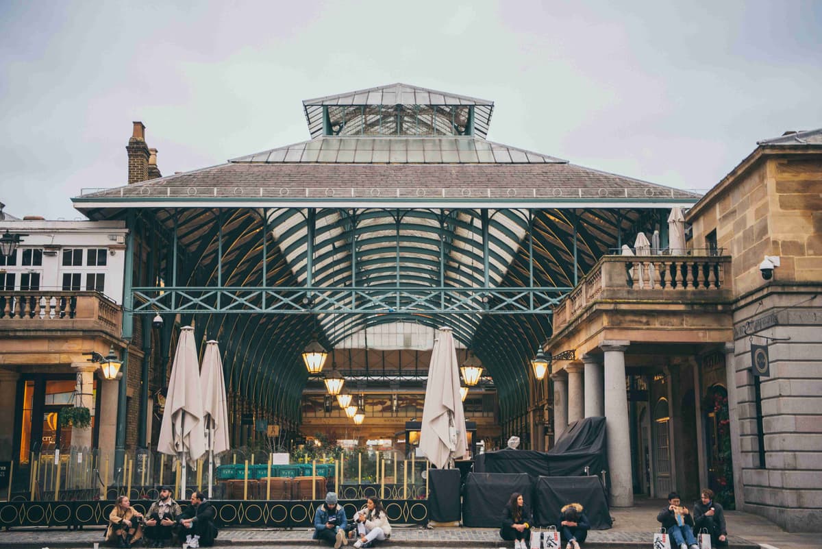 Covent Gardenin markkinoiden sisäänkäynti, jossa ihmiset rentoutuvat Lontoon ulkopuolella