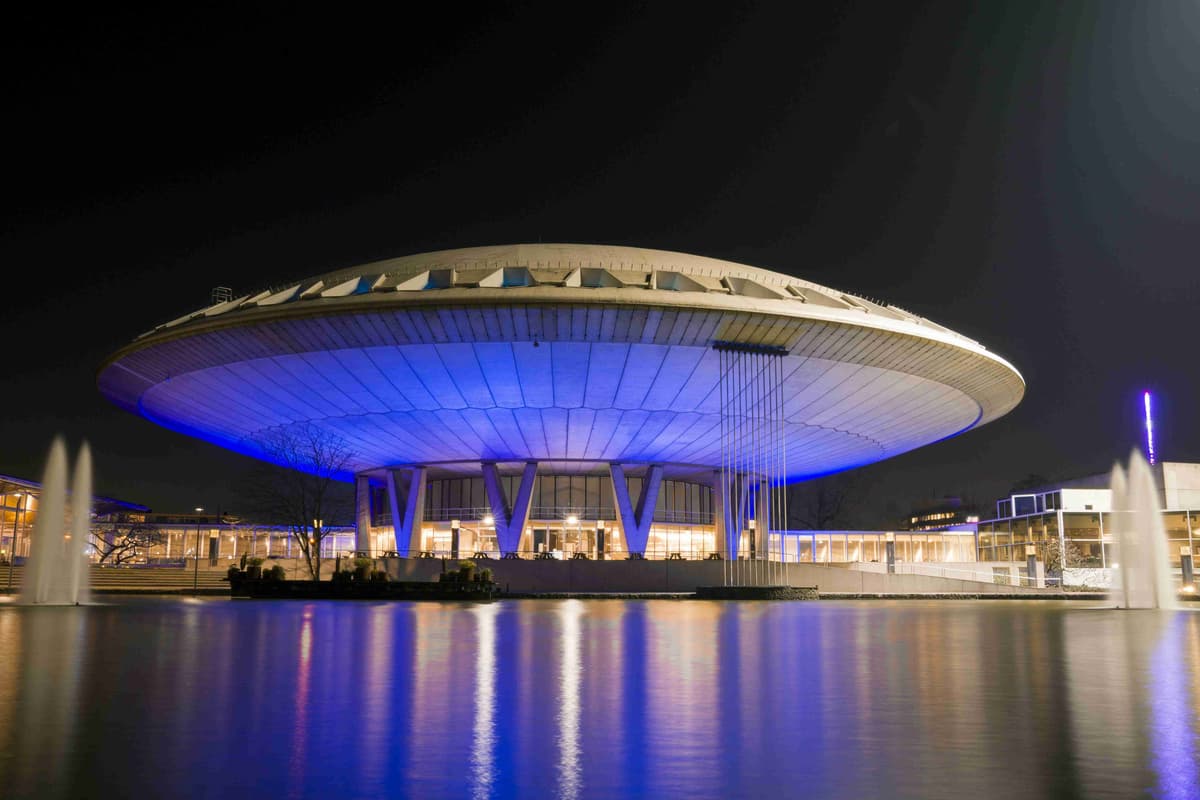 Futuristic Building with Blue Lighting Reflection on Water at Night