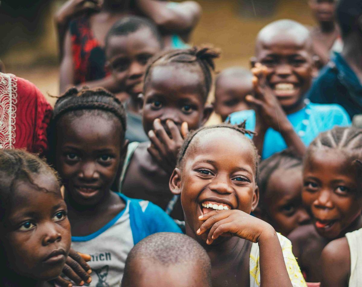 Ryhmä iloisia afrikkalaisia ​​lapsia, jotka hymyilevät ulkona