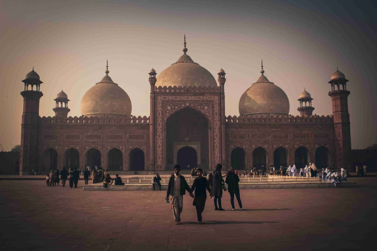 Historic Mughal Era Mosque at Sunset with Visitors