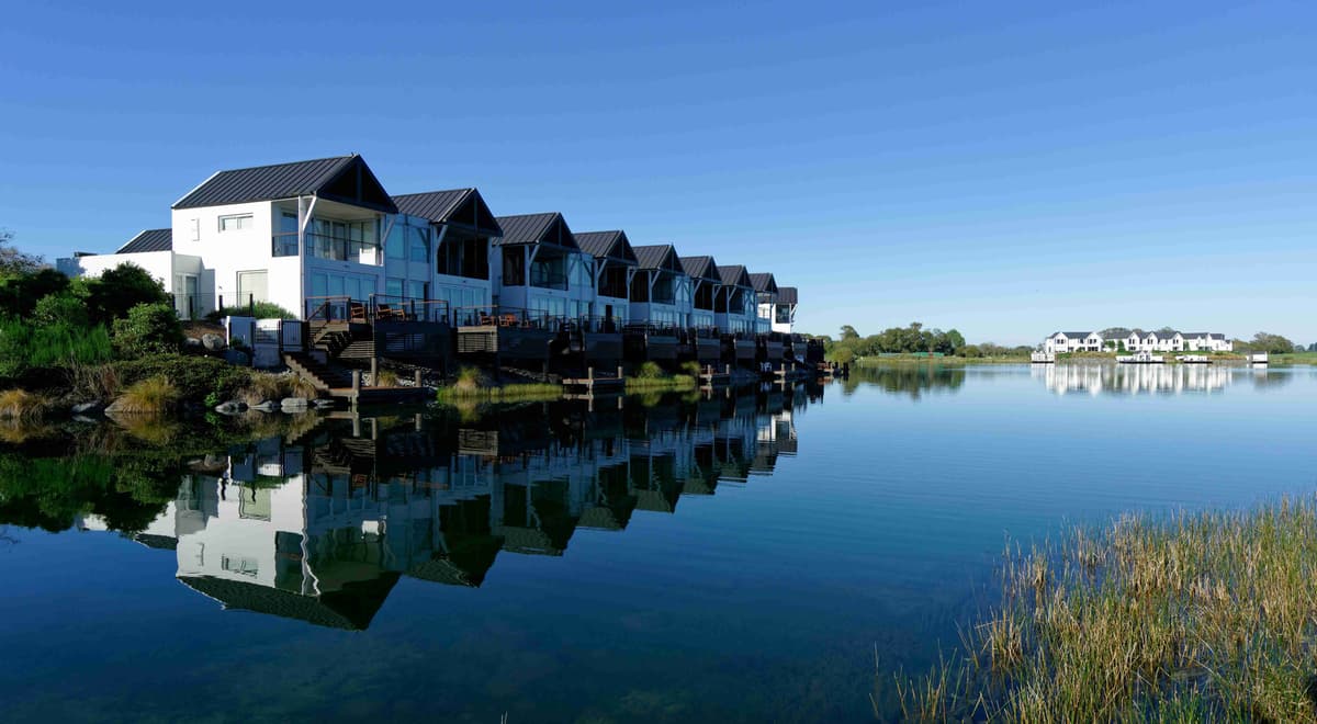 Reflexo de casas modernas à beira do lago