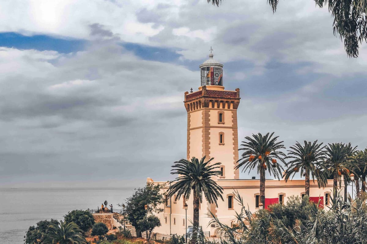 Phare parmi les palmiers avec fond de ciel nuageux