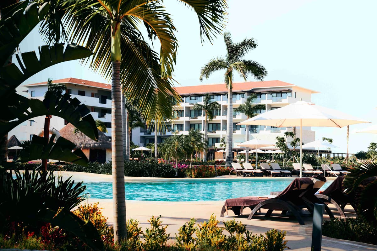 Resort de luxo à beira da piscina com palmeiras tropicais