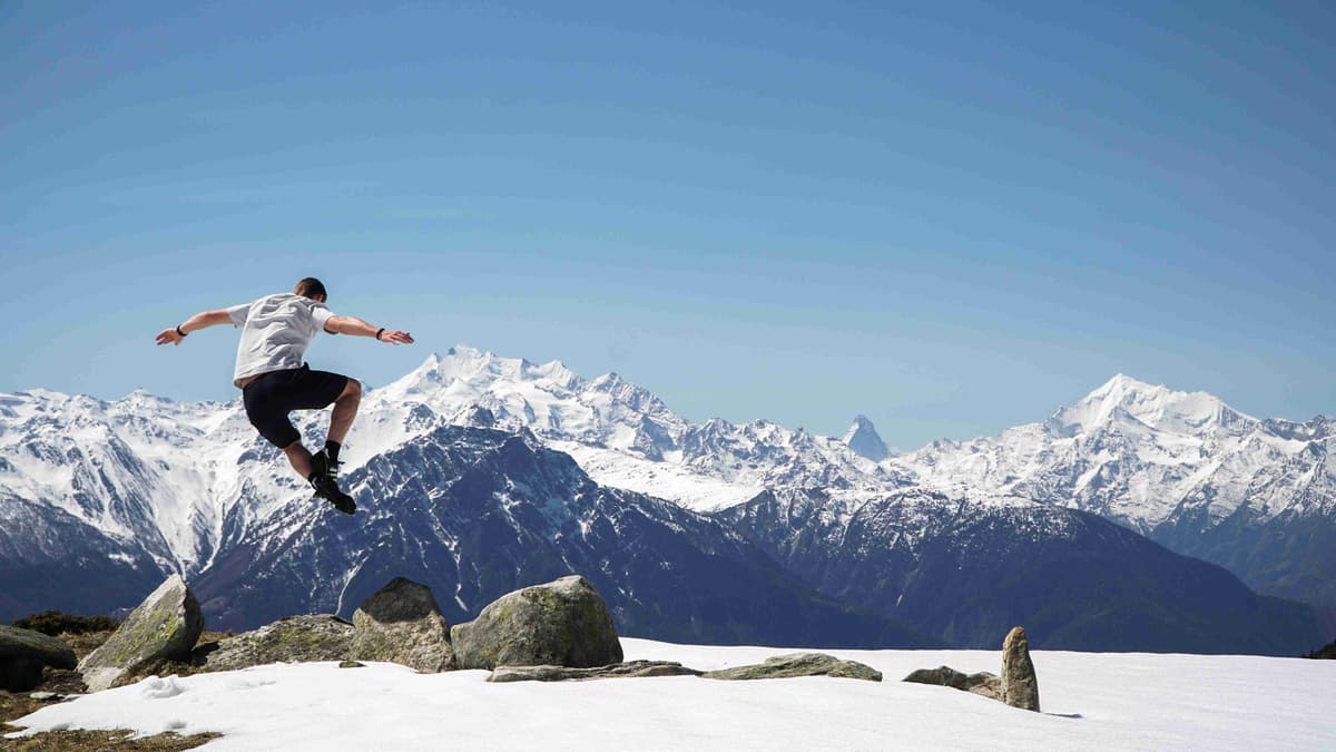 Man Jumping Against Mountainous Backdrop
