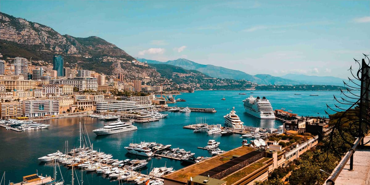 Mediterrán kikötőre néző luxusjachtok és városkép