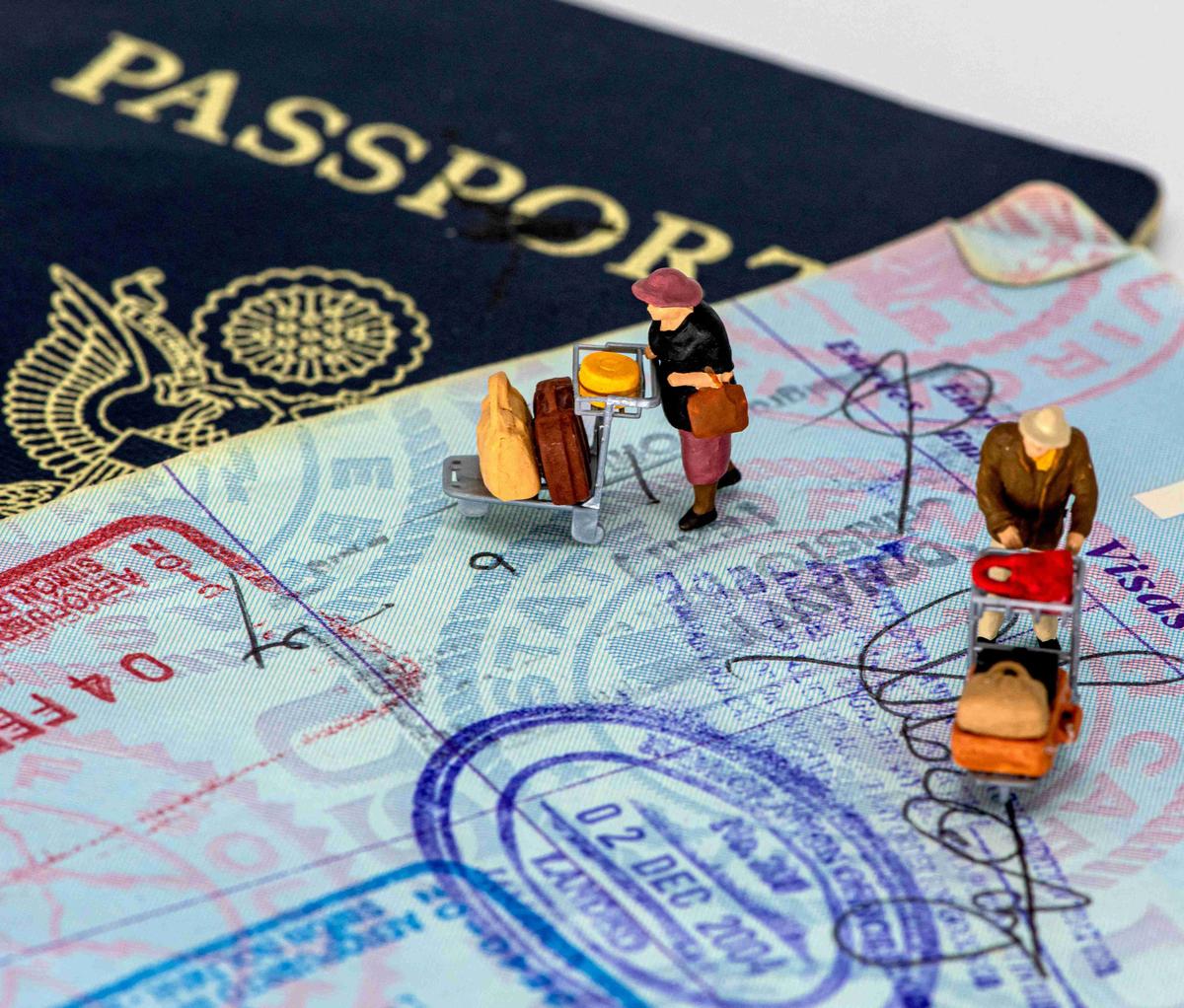 Miniature Figures on Passport with Travel Stamps
