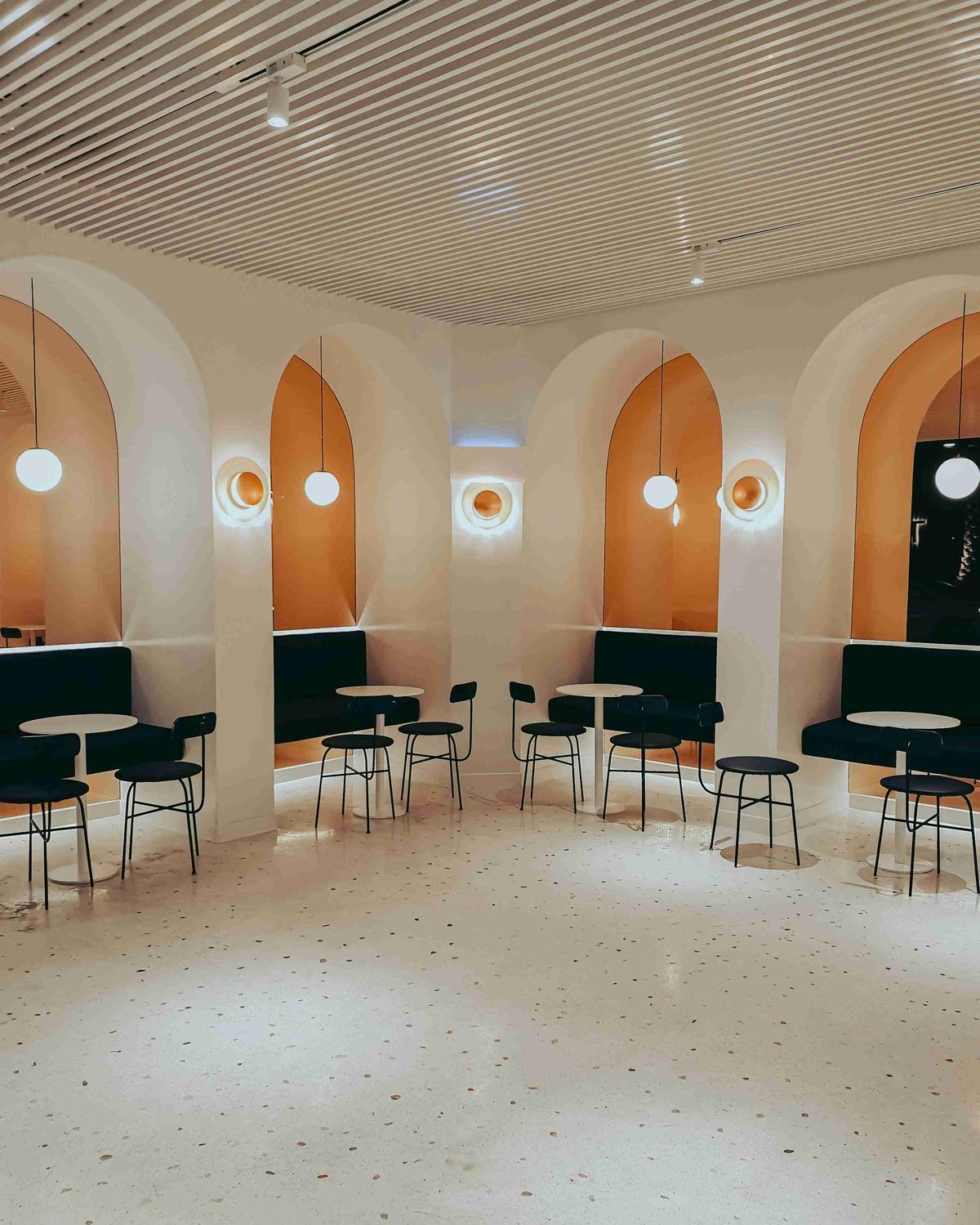 Modern Cafe Interior with Arched Walls and Spherical Lights