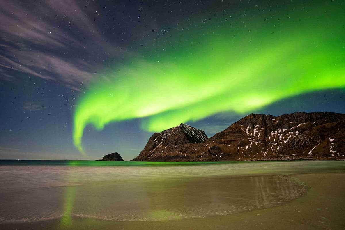 Northern Lights Display Above Mountain by Beach