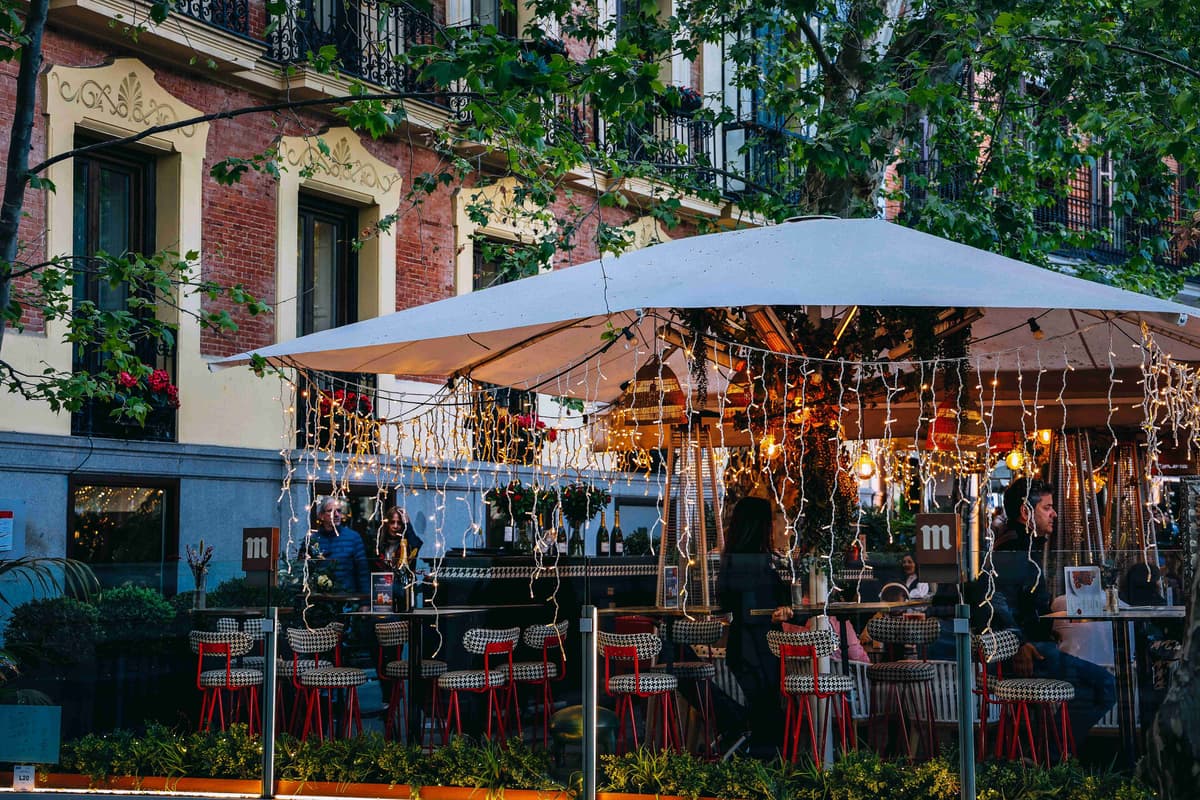 Outdoor Cafe with String Lights and Greenery