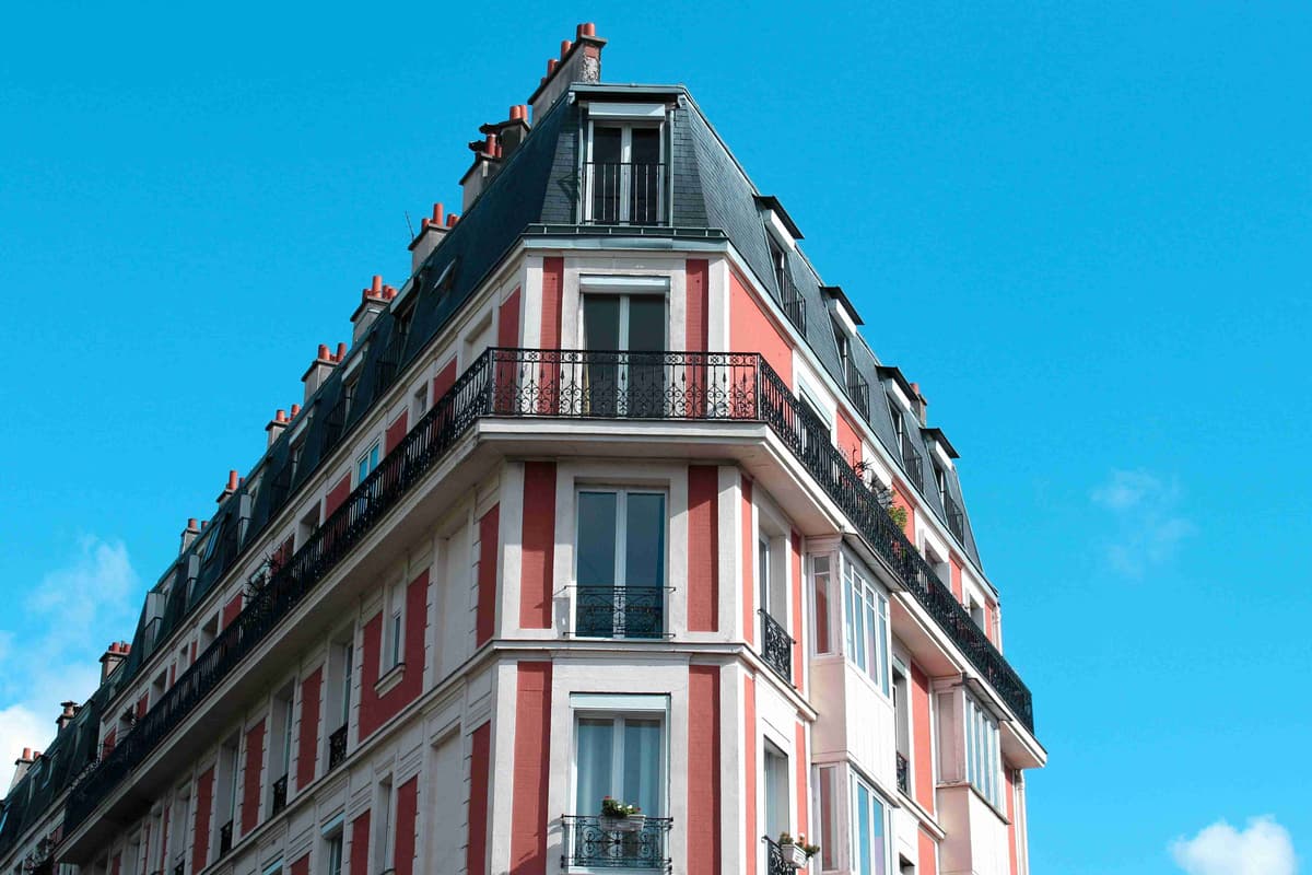 Parisian Corner Building with Red and White Facades Against Blue Sky