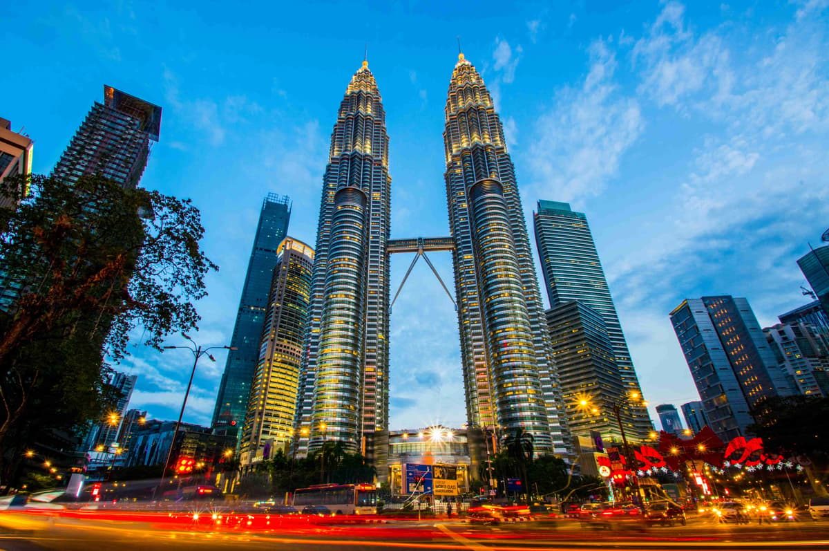 Petronas Towers Kuala Lumpur in der Abenddämmerung mit Stadtverkehr