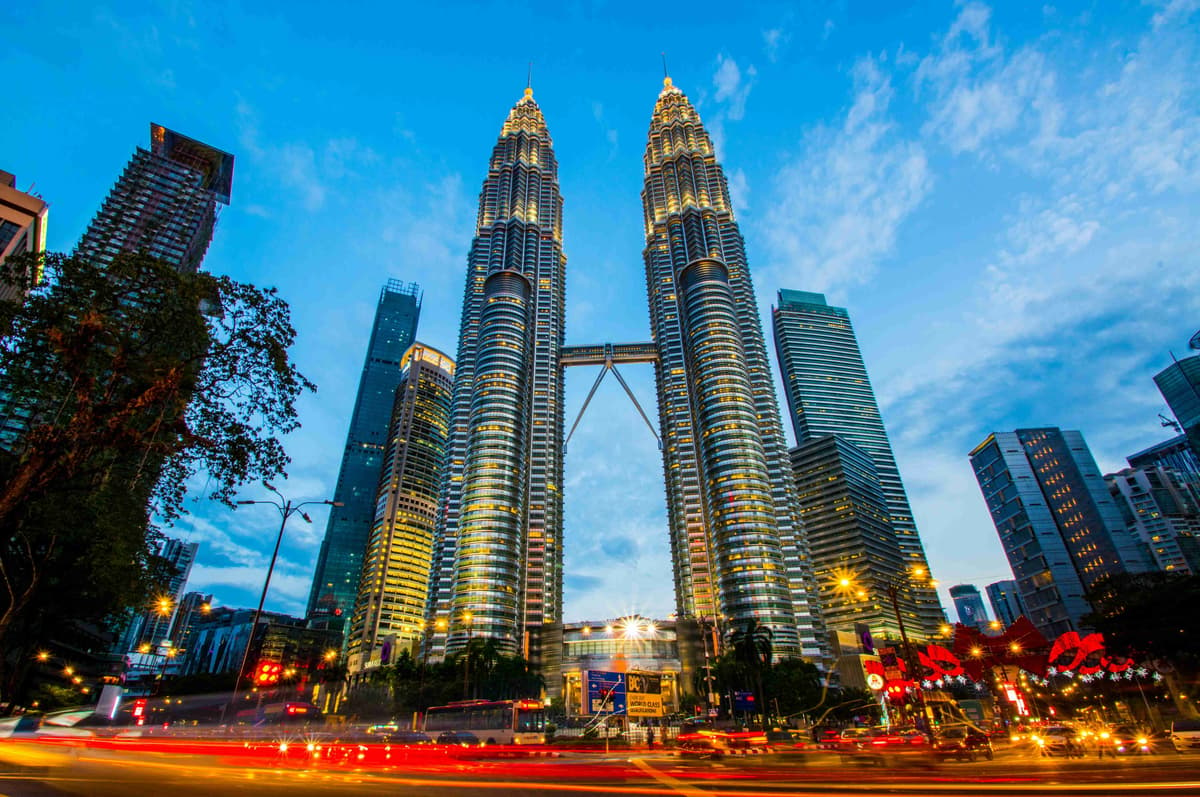 Tháp đôi Petronas lúc hoàng hôn với ánh đèn thành phố Kuala Lumpur