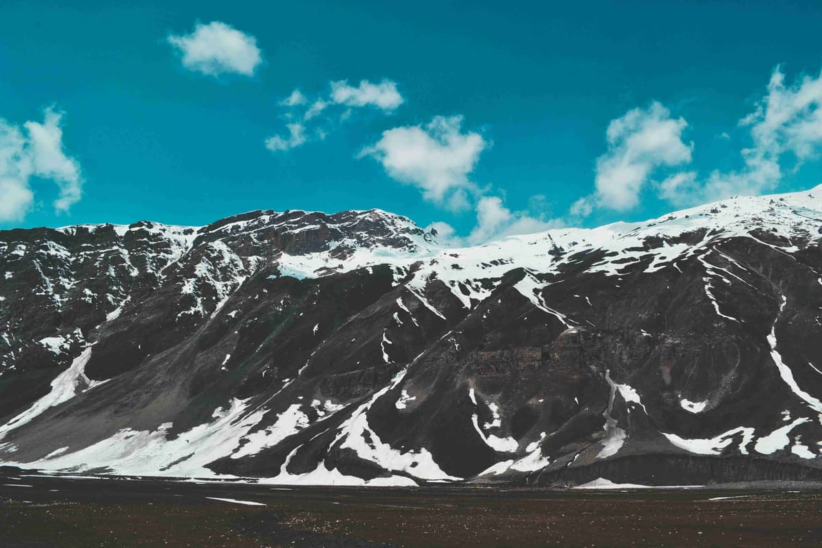 Snødekket fjellkjede under blå himmel