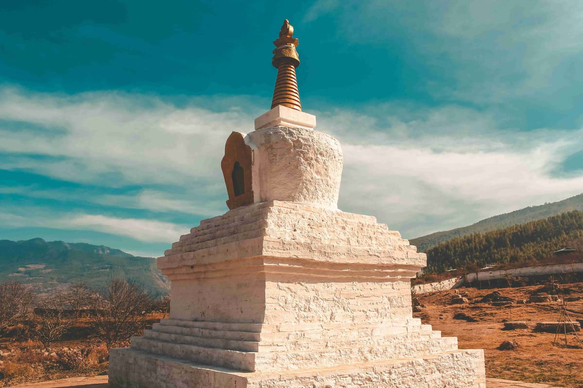 Sunny Day at Traditional Stupa With Mountain Backdrop