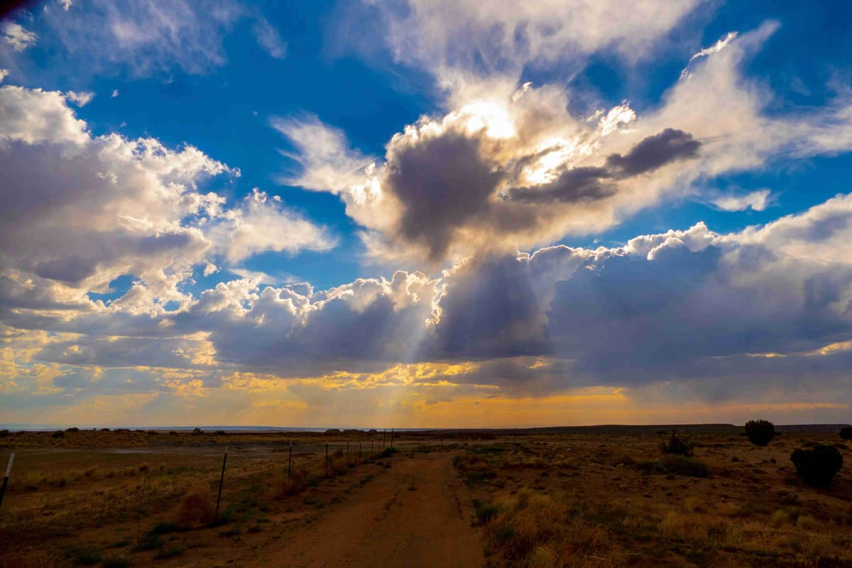 Päikesekiired piiluvad läbi pilvede üle kõrbemaastiku