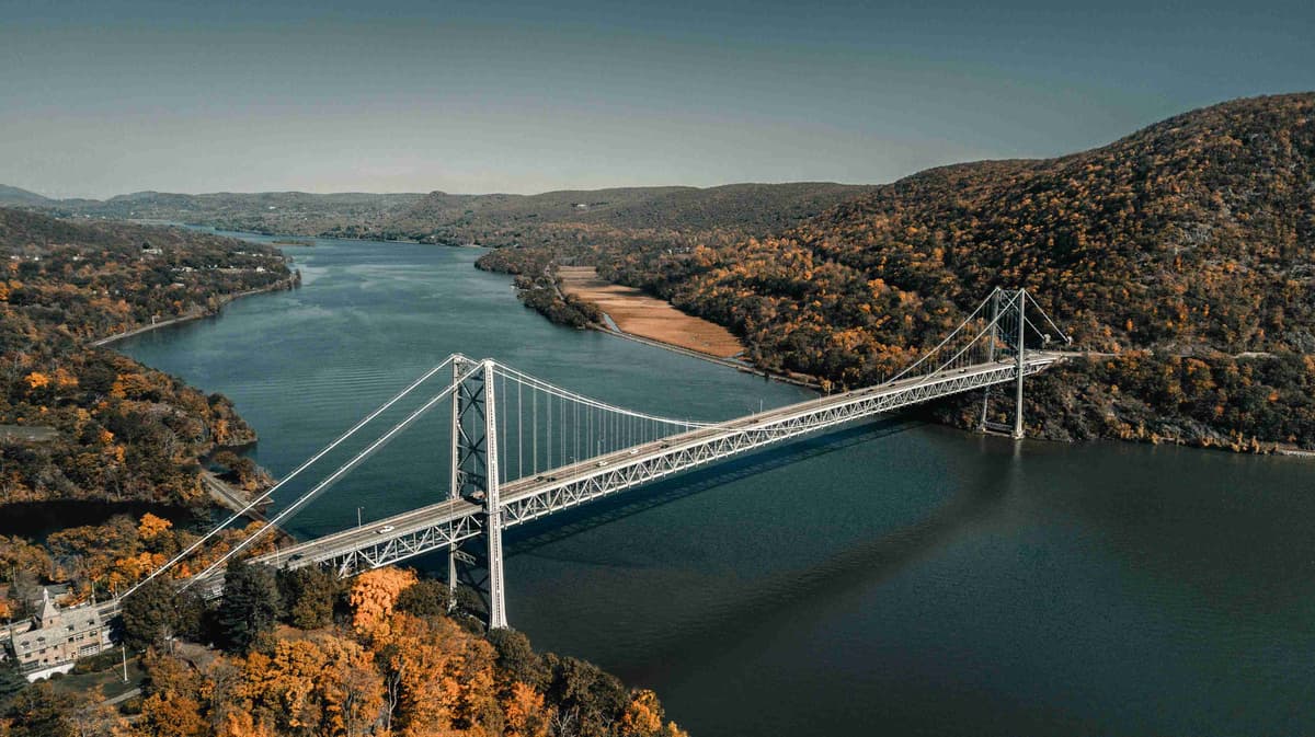 Suspension Bridge Over Autumn River Landscape