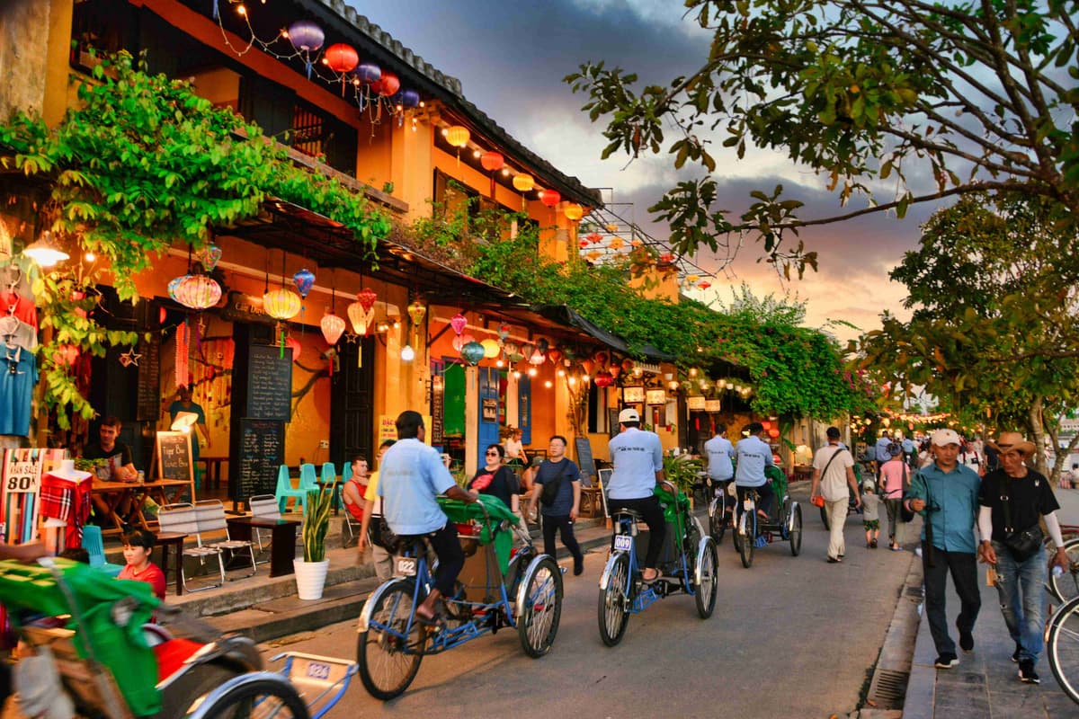 مشهد الشفق في مدينة هوي آن القديمة مع الفوانيس وراكبي الدراجات