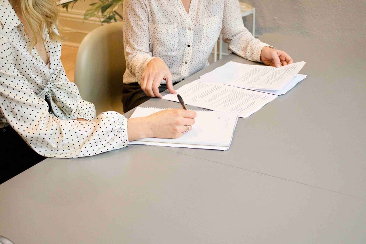 Duas pessoas revisando documentos com capacidade