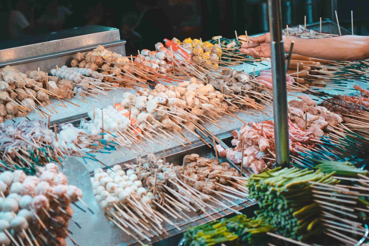 Variety of Skewered Foods Ready for Grilling at Night Market