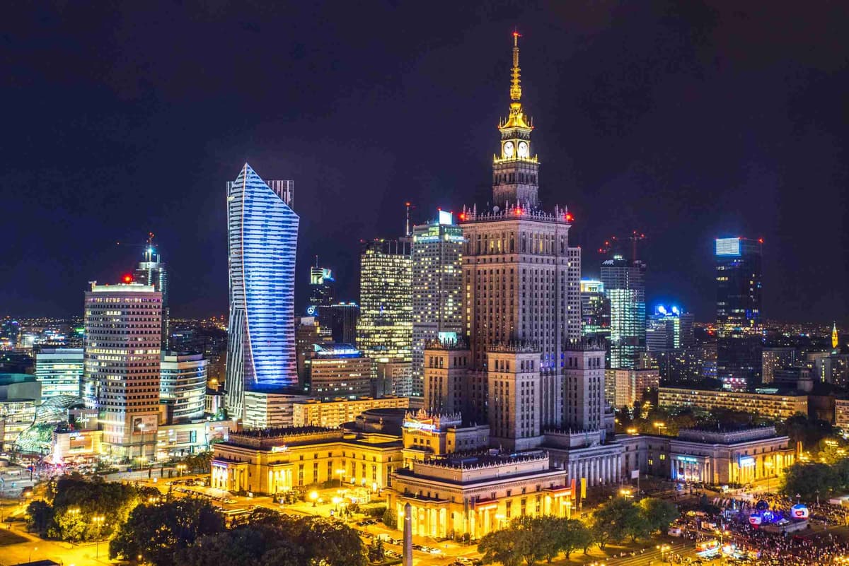 Varsó éjszakai látképe megvilágított felhőkarcolókkal