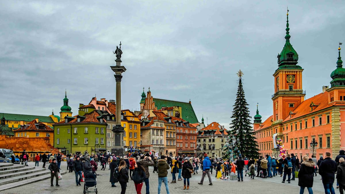 Winterliche Menschenmenge auf dem historischen Platz mit Weihnachtsbaum