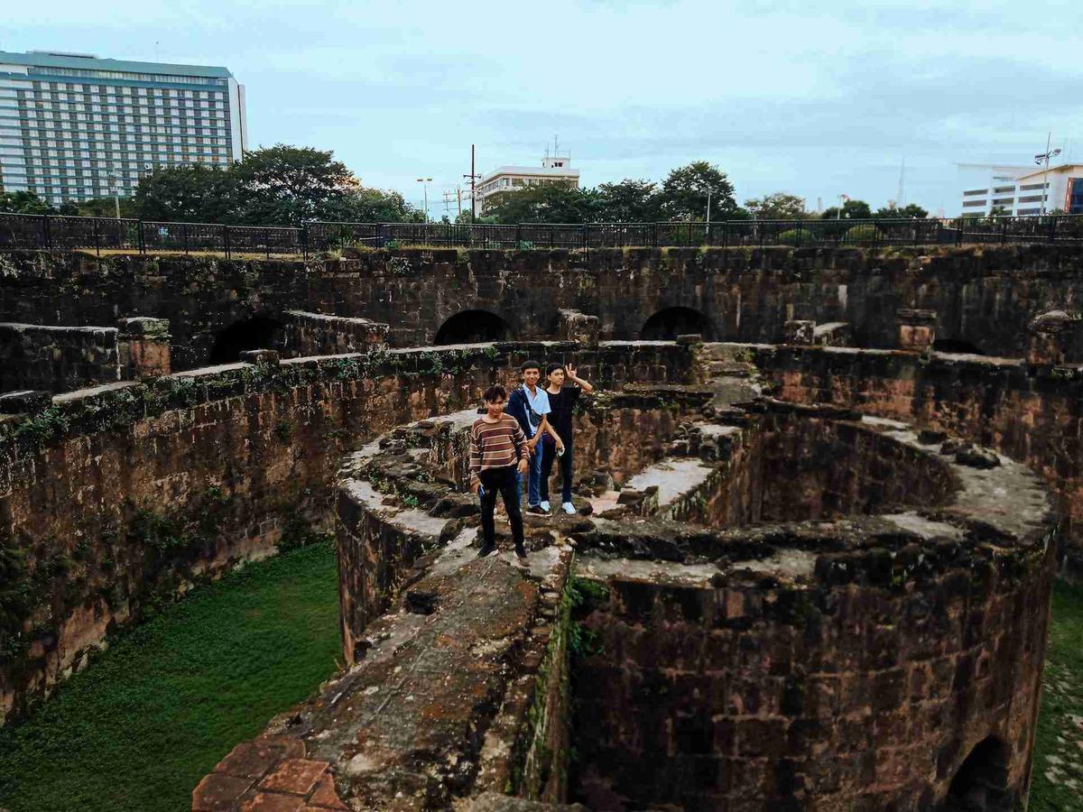 Tūristi, kas pēta Santjago forta vēsturiskās drupas Manilā