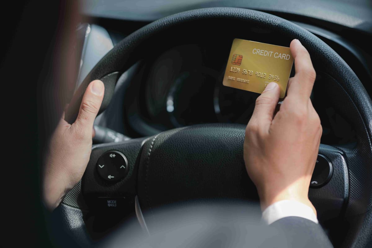 An Asian man in a formal suit is in a car