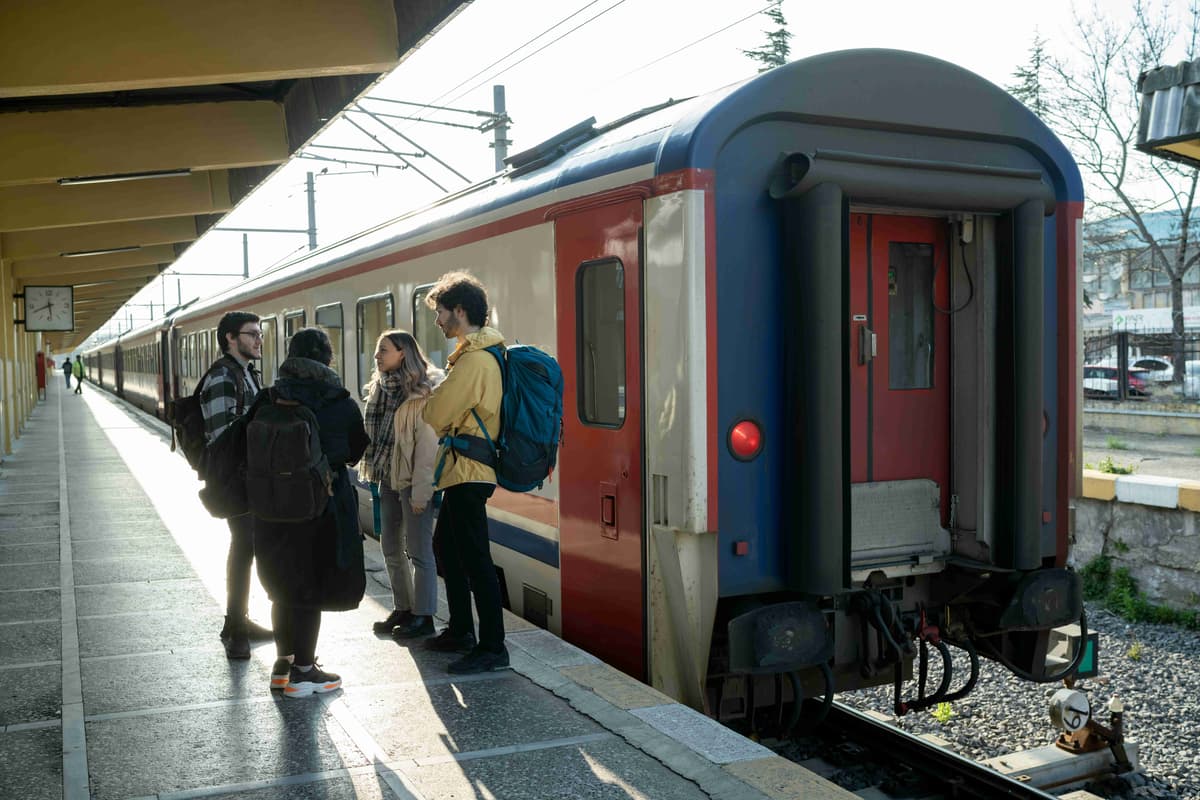 en-grupp-folk-står-på-en-perrong-bredvid-ett-tåg