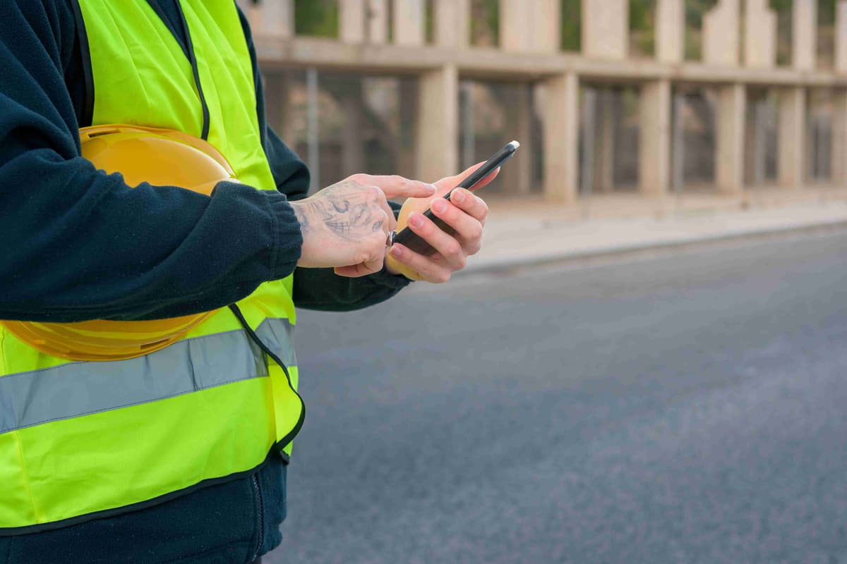 Close-up of a laborer looking at a phone