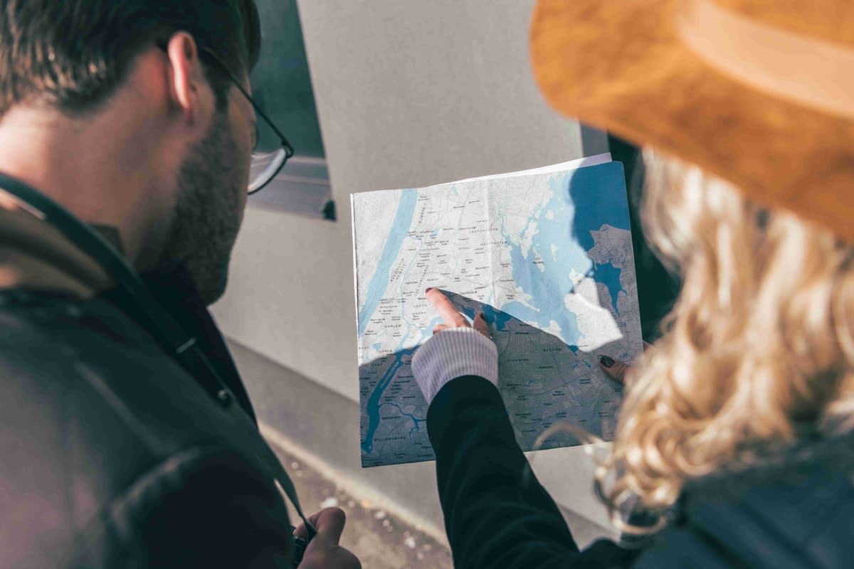 cropped-shot-of-young-couple-pointing-at-map