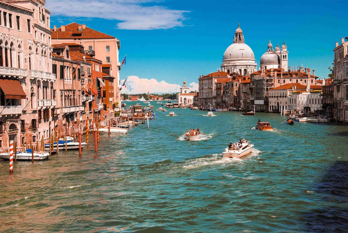 Busy Grand Canal with boats and classic Venetian architecture.
