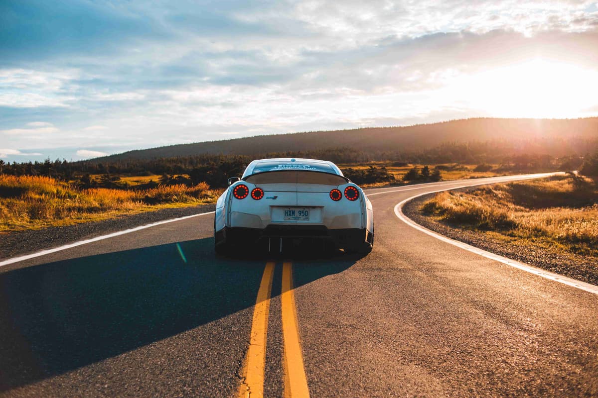 Sports Car On Road At Sunset