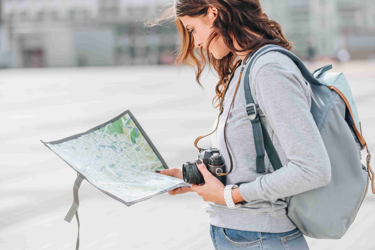 female-traveler-with-photo-camera-looking-at-map