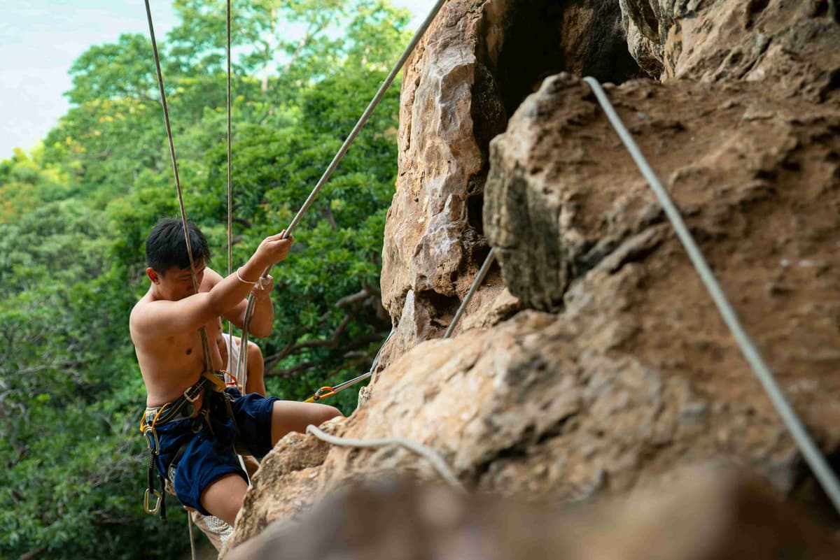 Man Rock Climbing with Safety Ropes