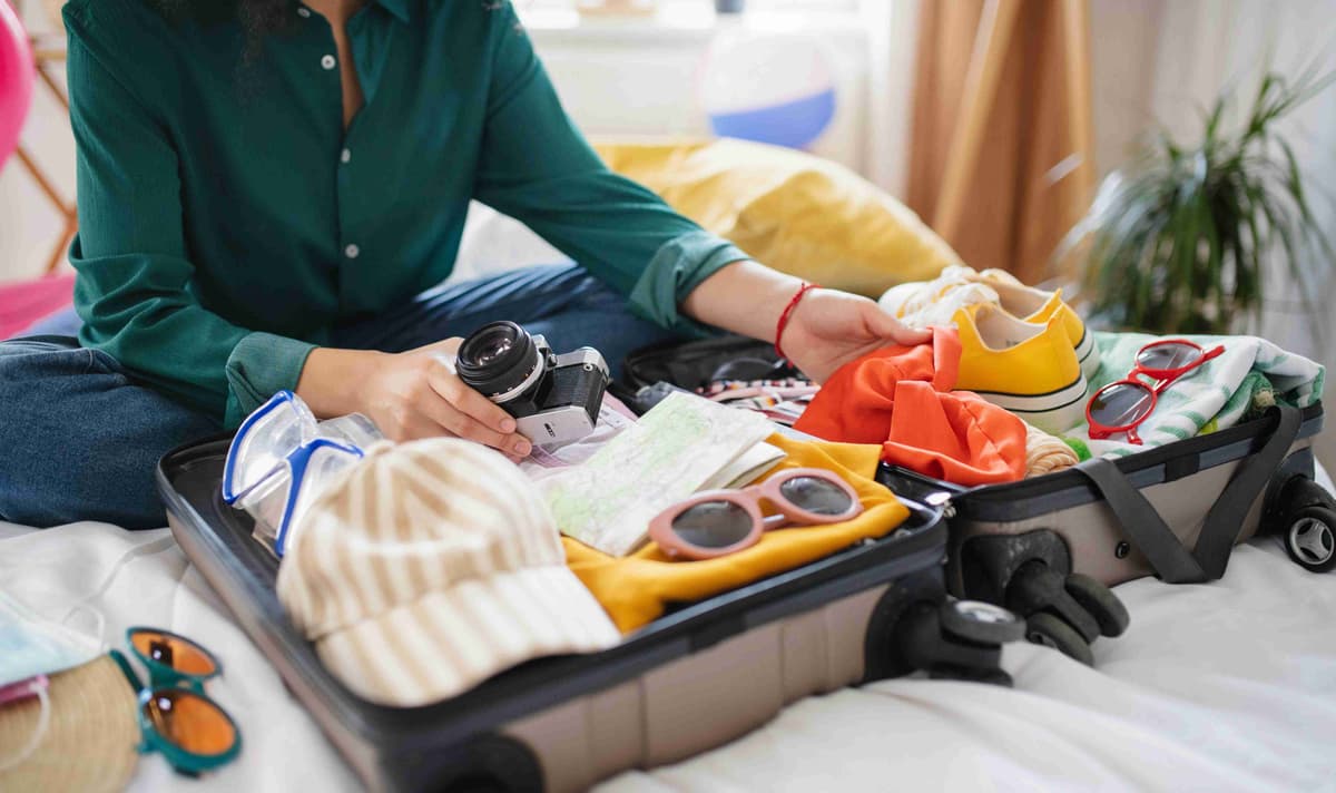 unrecognizable-young-woman-with-suitcase-packing-for-holiday