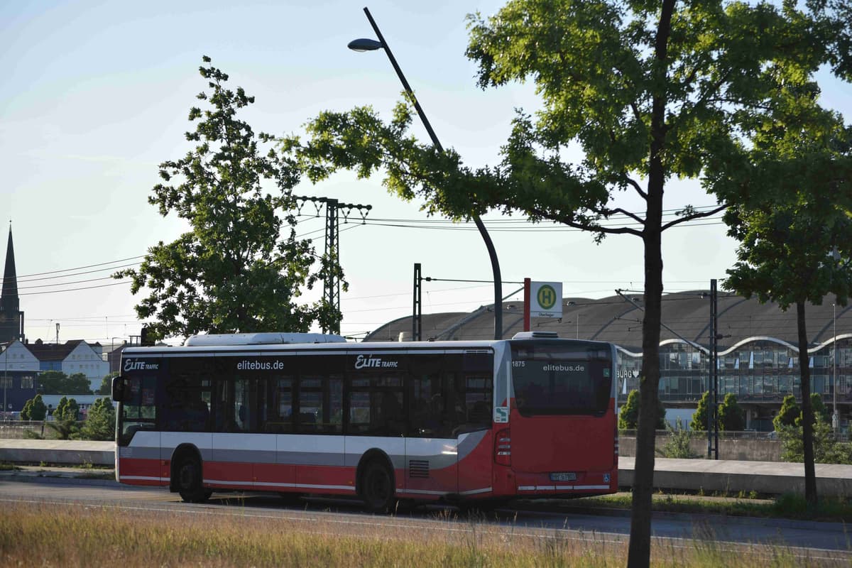 a red and white bus driving down a street