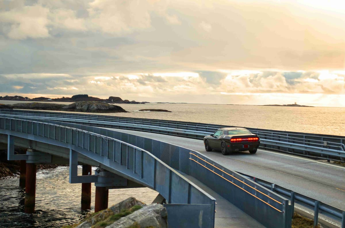 black suv on gray concrete bridge under gray cloudy sky